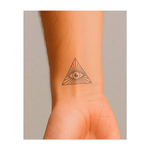 Un occhio racchiuso in un triangolo che emette raggi di luce verso l'esterno. Questo tatuaggio simboleggia saggezza, consapevolezza e intuizione spirituale, ideale per chi cerca una conoscenza più profonda e l'illuminazione.