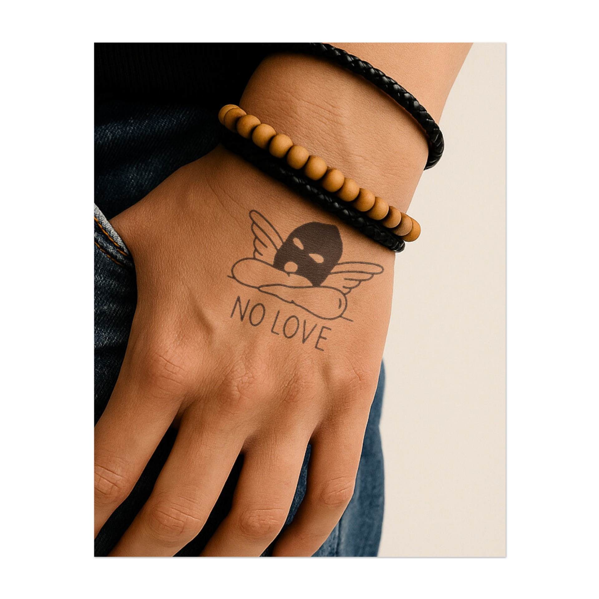 Una maschera con ali d'angelo poggiata sulla scritta "NO LOVE" simboleggia il conflitto tra vulnerabilità e protezione del proprio cuore.