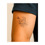 Un cuore trafitto da una freccia con uno striscione che dice "AMO MIA MADRE". Questo tatuaggio simboleggia il forte legame tra madre e figlio.