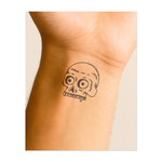 Un teschio cartoon con tratti esagerati. Rappresenta l'umorismo, un approccio giocoso alla mortalità o uno stile unico. Un design sorprendente e spensierato.