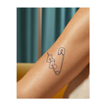 Una spilla da balia che trafigge due cuori. Rappresenta l'amore sicuro, una storia d'amore non convenzionale o un'estetica punk.