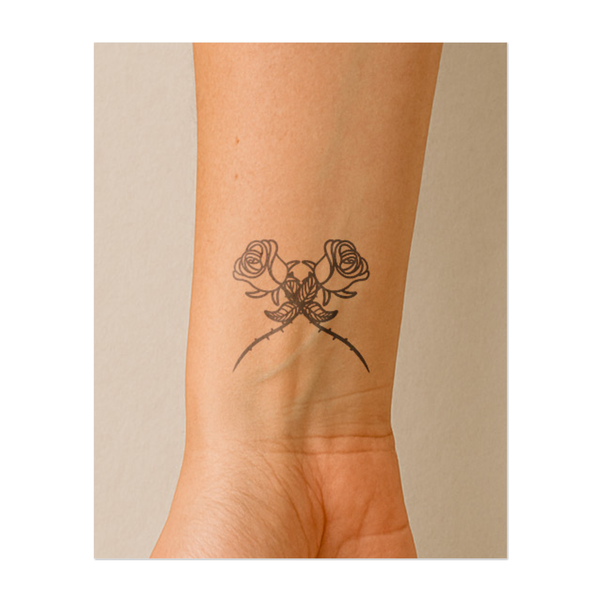 Due rose con spine intrecciate. Simboleggiano bellezza e dolore, amore con ostacoli, o un classico simbolo di romanticismo con un tocco oscuro.