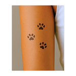 Tre divertenti impronte di zampe nere disposte in un delicato e sinuoso percorso. Questo design semplice ma incantevole cattura lo spirito degli animali, dell'avventura e della compagnia; perfetto per gli amanti degli animali che hanno un debole per le zampe.