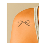 Un elegante fiocco nero con passanti fluidi ed estremità appuntite, incastonato tra due delicati dettagli. Questo design sofisticato simboleggia fascino, femminilità e cura dei dettagli, perfetto per un look delicato ed elegante.