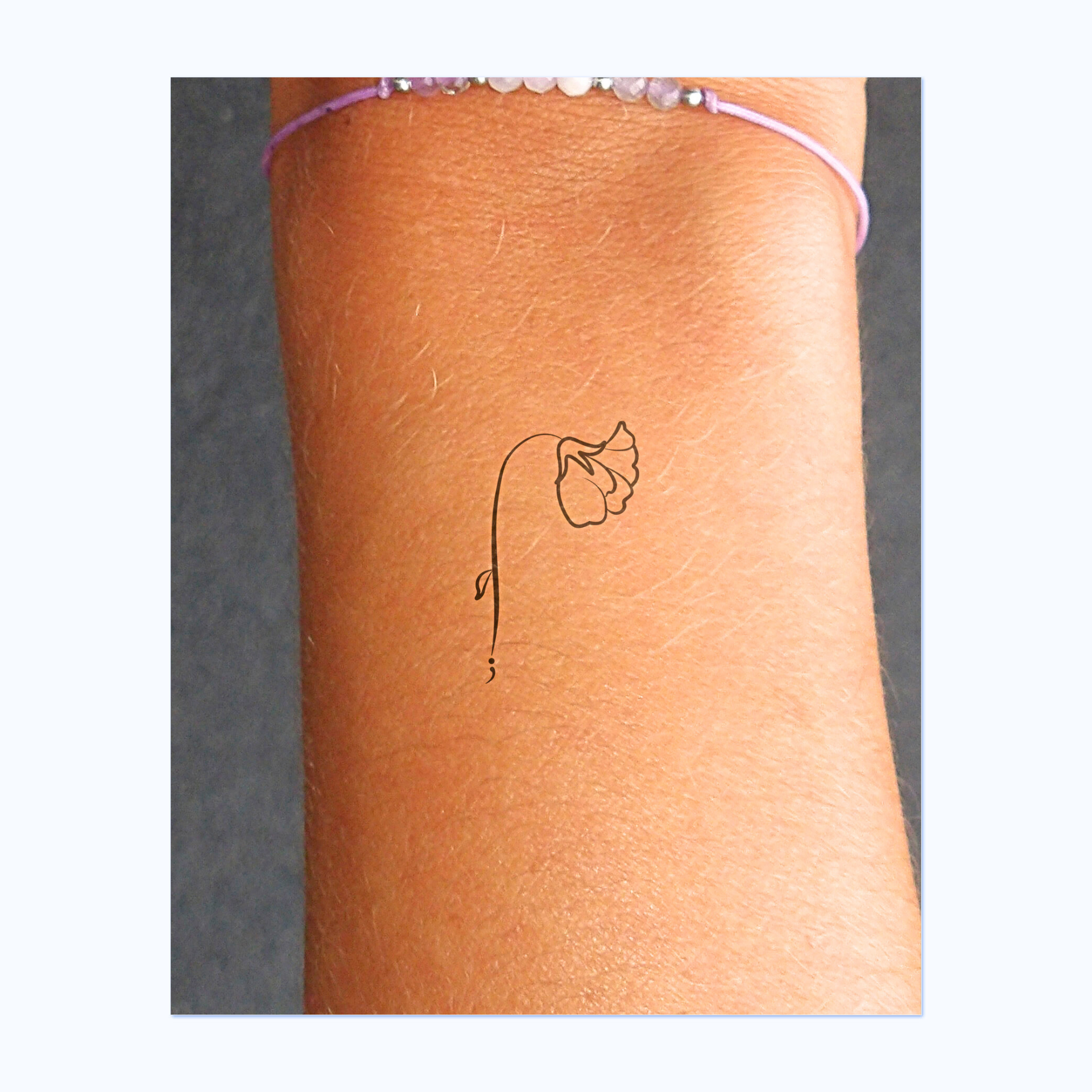 Un fiore elegantemente ricurvo verso il basso, con petali ricurvi e uno stelo ornato da una piccola foglia. Alla base si trova un delicato punto e virgola, un potente simbolo di forza, speranza e futuro.