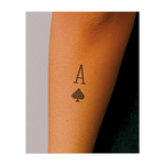 Una sorprendente e iconica "A" abbinata al classico simbolo di picche. Questo tatuaggio nero a contrasto incarna fortuna, mistero e sicurezza; ideale per una dichiarazione d'amore senza tempo e potente, in uno stile pulito e minimalista.
