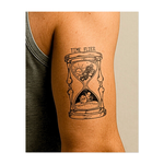 Questo potente tatuaggio raffigura una clessidra sormontata da uno scheletro che prende il sole e una lapide con la scritta "RIP". Come la sabbia che scorre tra la vita e la morte, cattura la transitorietà dell'esistenza e l'inevitabile passare del tempo.